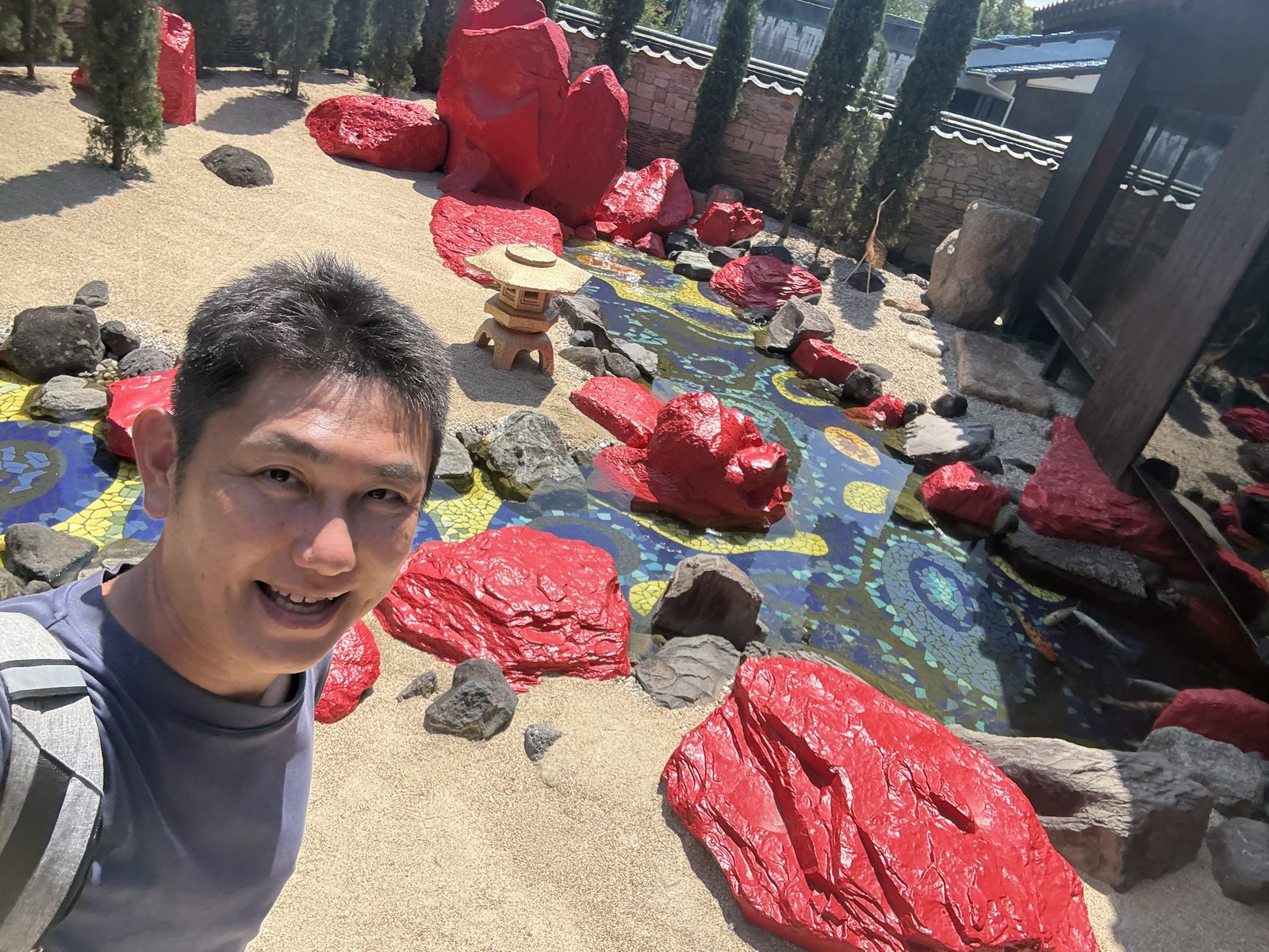 豊島横尾館の赤い岩とモザイクの池がある庭園