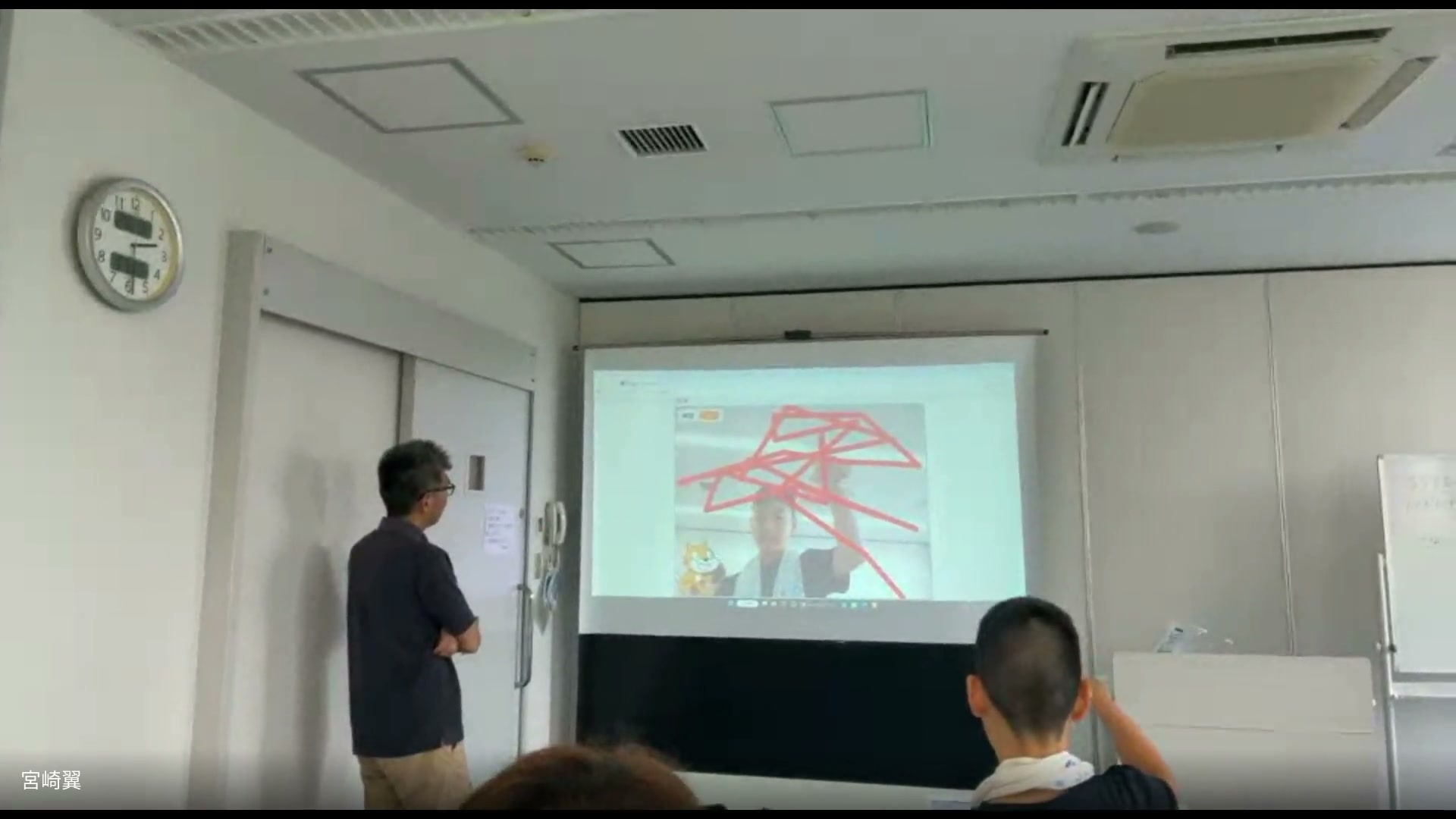 指先の動きで赤い線を描くゲームをプロジェクターに映したデモ